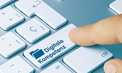 Finger weist auf Taste einer Computer-Tastatur mit der Aufschrift Digitale Kompetenz. 