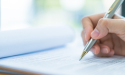 Hand hält Stift und schreibt