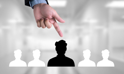 Finger weist auf Person aus Personengruppe
